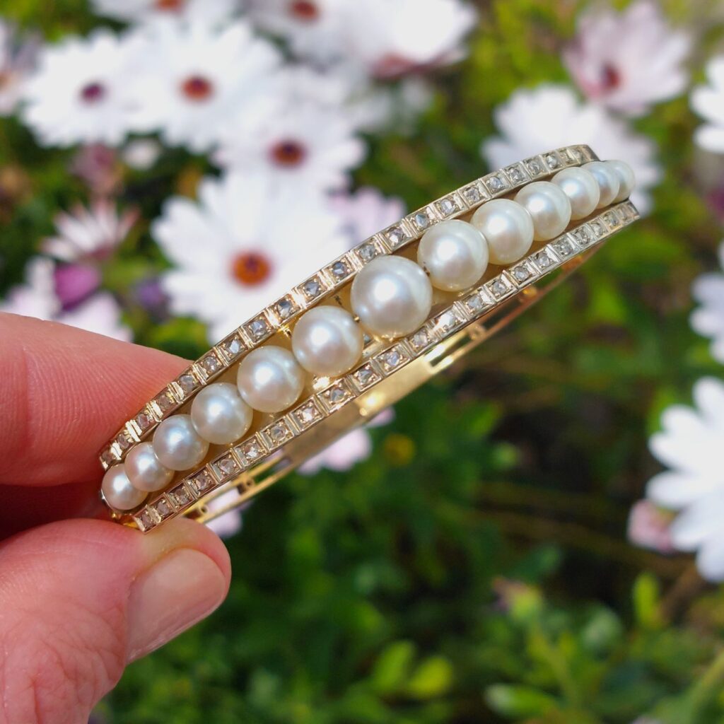 Bracelet jonc Belle Époque ouvrant - or et perles, vers 1900. Vue en lumière naturelle sur les perles et leur brillance.